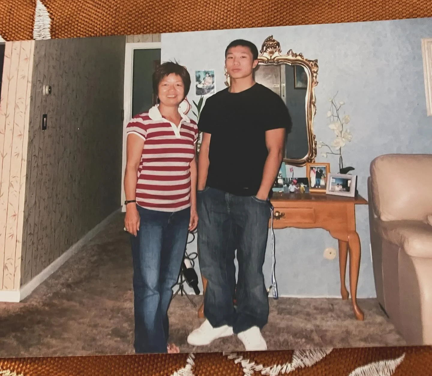 Two people standing together in a living room.